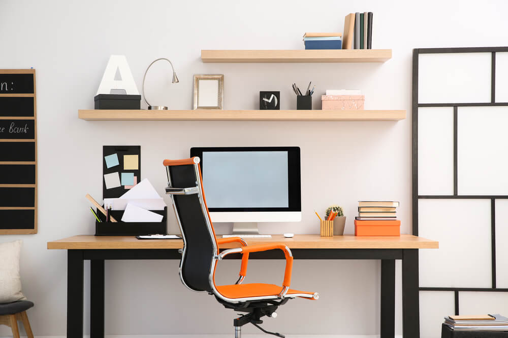 PCを置いた机とオレンジの椅子を使った在宅スペース