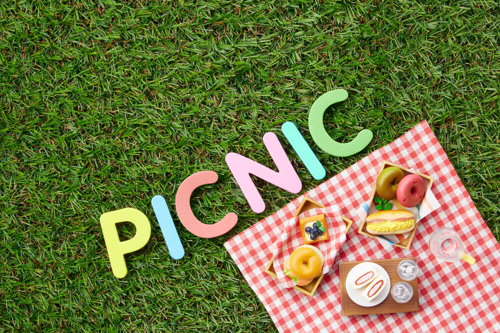 ピクニックの文字とレジャーシートとお弁当