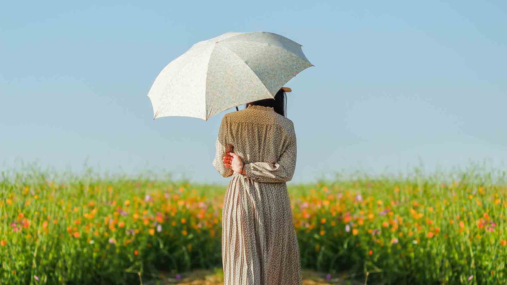 花畑で日傘をさす女性