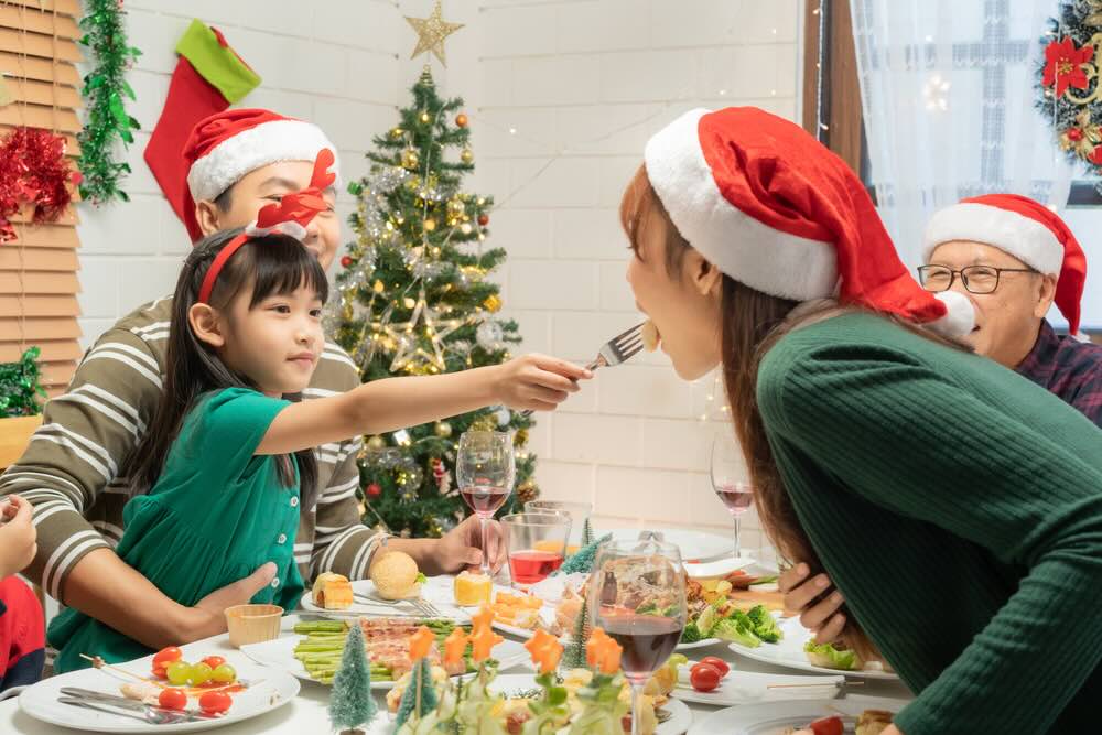 クリスマス仮装をして食事を楽しむ家族