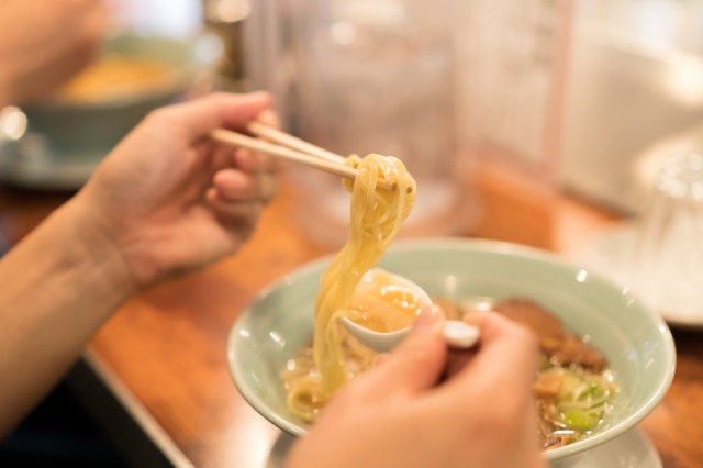 ラーメン店でラーメンを食べる客