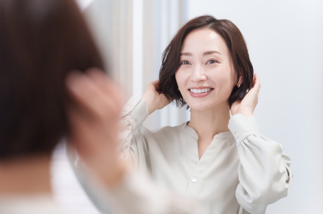 ヘアオイルをつける女性